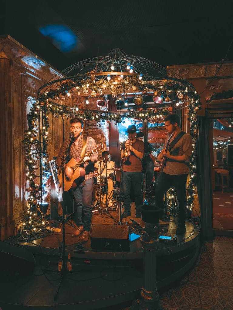 Igor Landy performing with his band at Alte Liebe in Hamburg, surrounded by warm string lights
