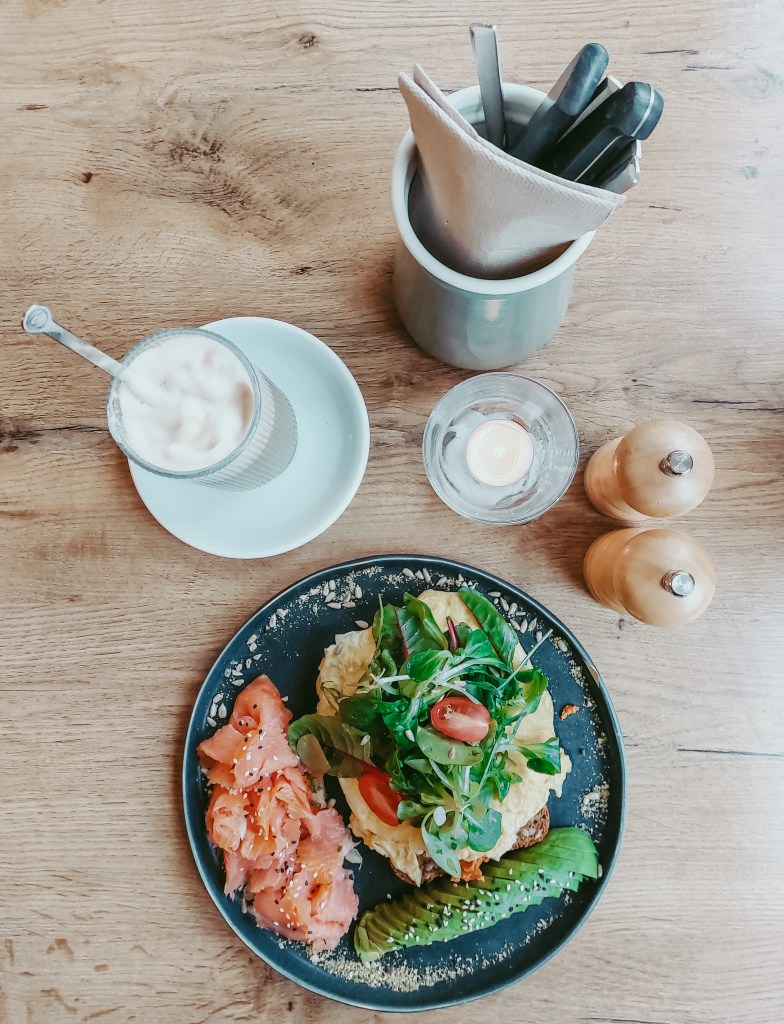 Scrambled eggs with salmon, avocado and salad served with gluten-free bread at Café Mama Silvia.