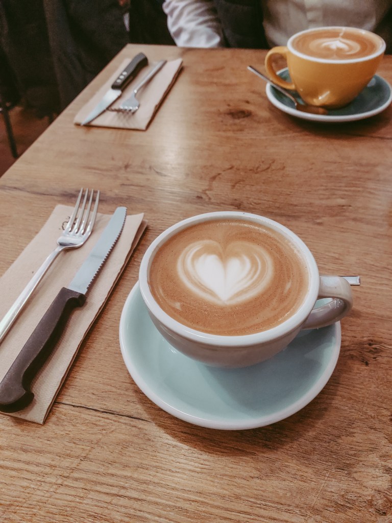 Two cappuccinos on a table during a busy weekend brunch at Café Mama Silvia.