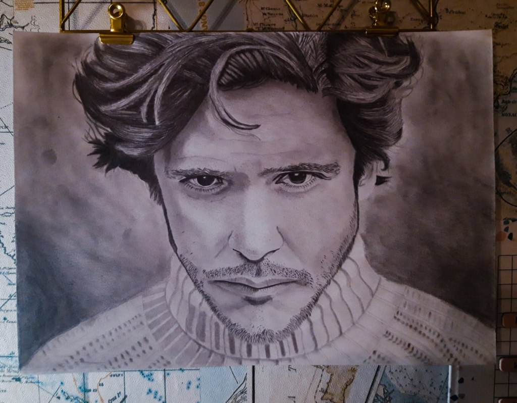 Hand-drawn pencil portrait of Jack Savoretti, displayed on a wall with metal clips