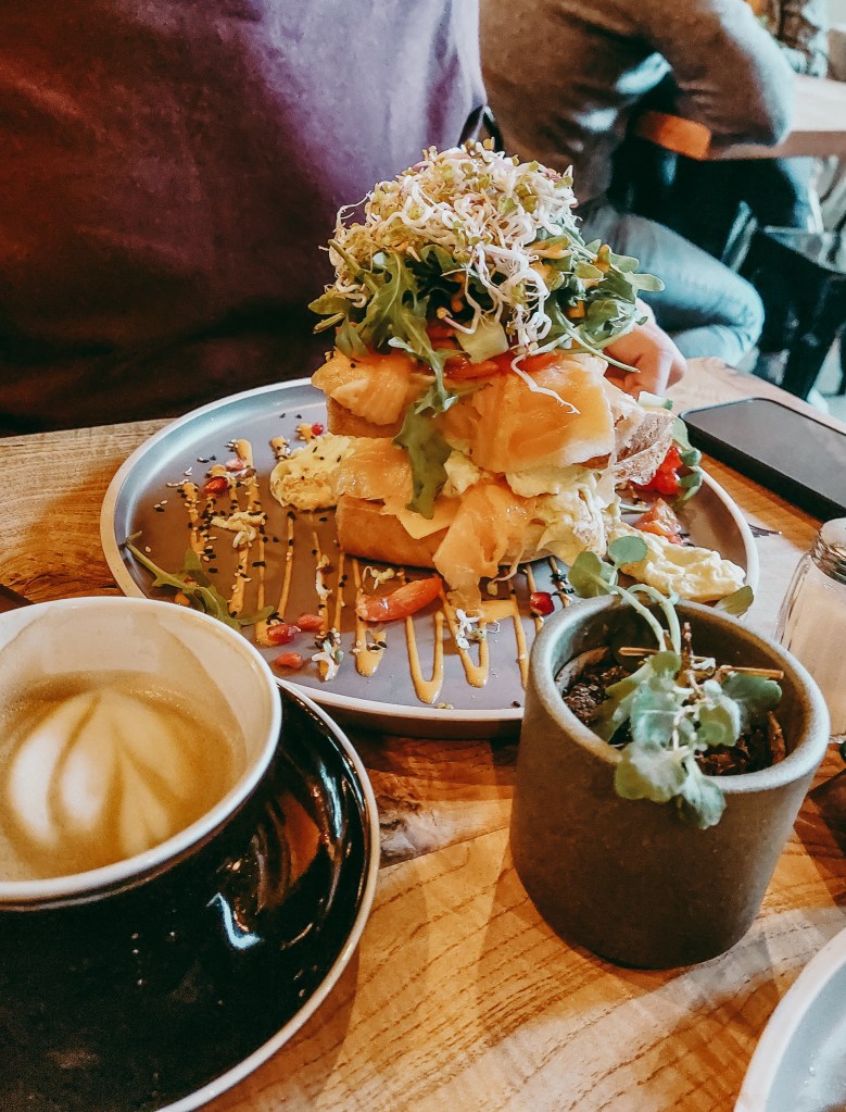 Towering Salmon-Drop brunch topped with salmon, rocket and sprouts, served on brioche at Dieter’s Café.
